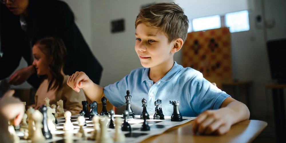 A young student focused on a chess board